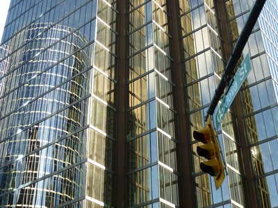 Close up of skyscraper windows with reflection of another skyscraper and traffic light in foreground with Cordova Street sign hanging adjacent, Cordova Street, Vancouver, Canada