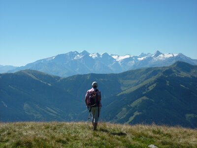 Man observing Hochkonig atop a grassy mountain on walking holiday, Maria Alm.JPG