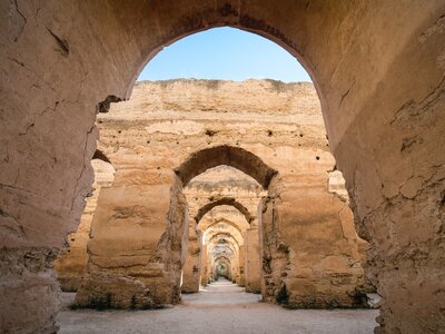 Centrally aligned view of towering stone archways from 17th century built for Meknes entrance to Heri es-Souani royal granary, Morocco, Africa