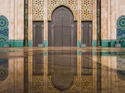 Hassan II mosque's big multipatterned and colourful gate reflected in rain water, Casablanca, Morocco, Africa