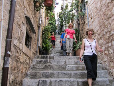 Ramble Worldwide walking holiday group descending stone stairway filled with plants and flowers in the old city of Dubrovnik, Croatia